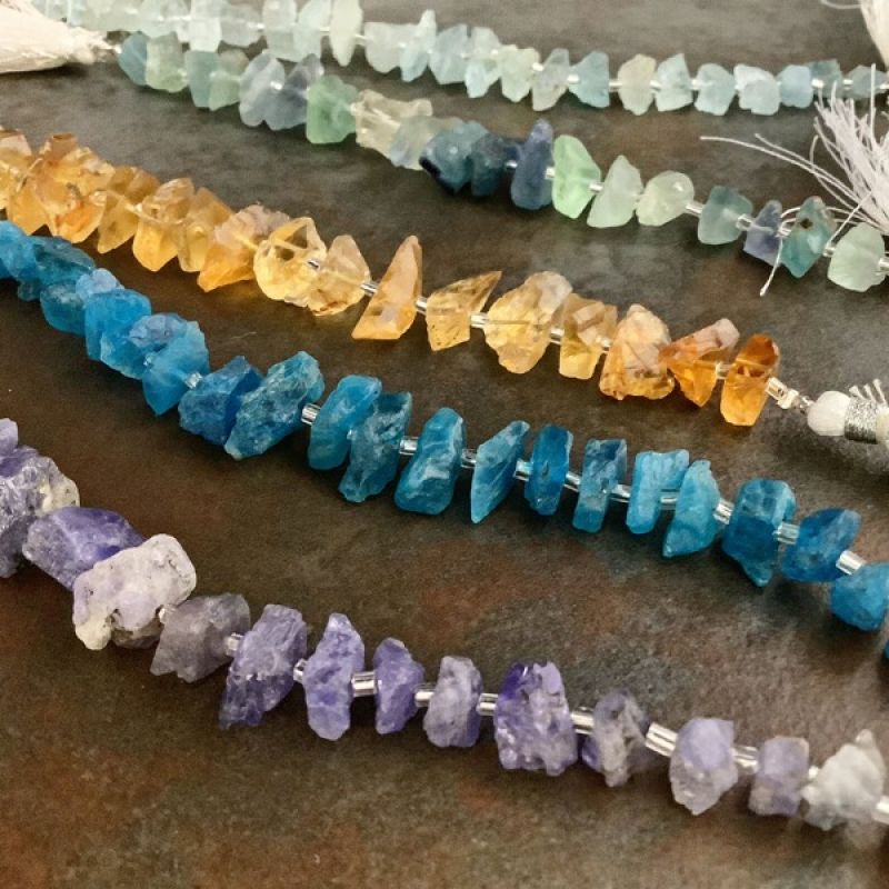 A collection of raw tanzanite, neon apatite, aquamarine, citrine and fluorite nugget beads that make up the naturals earring collection.